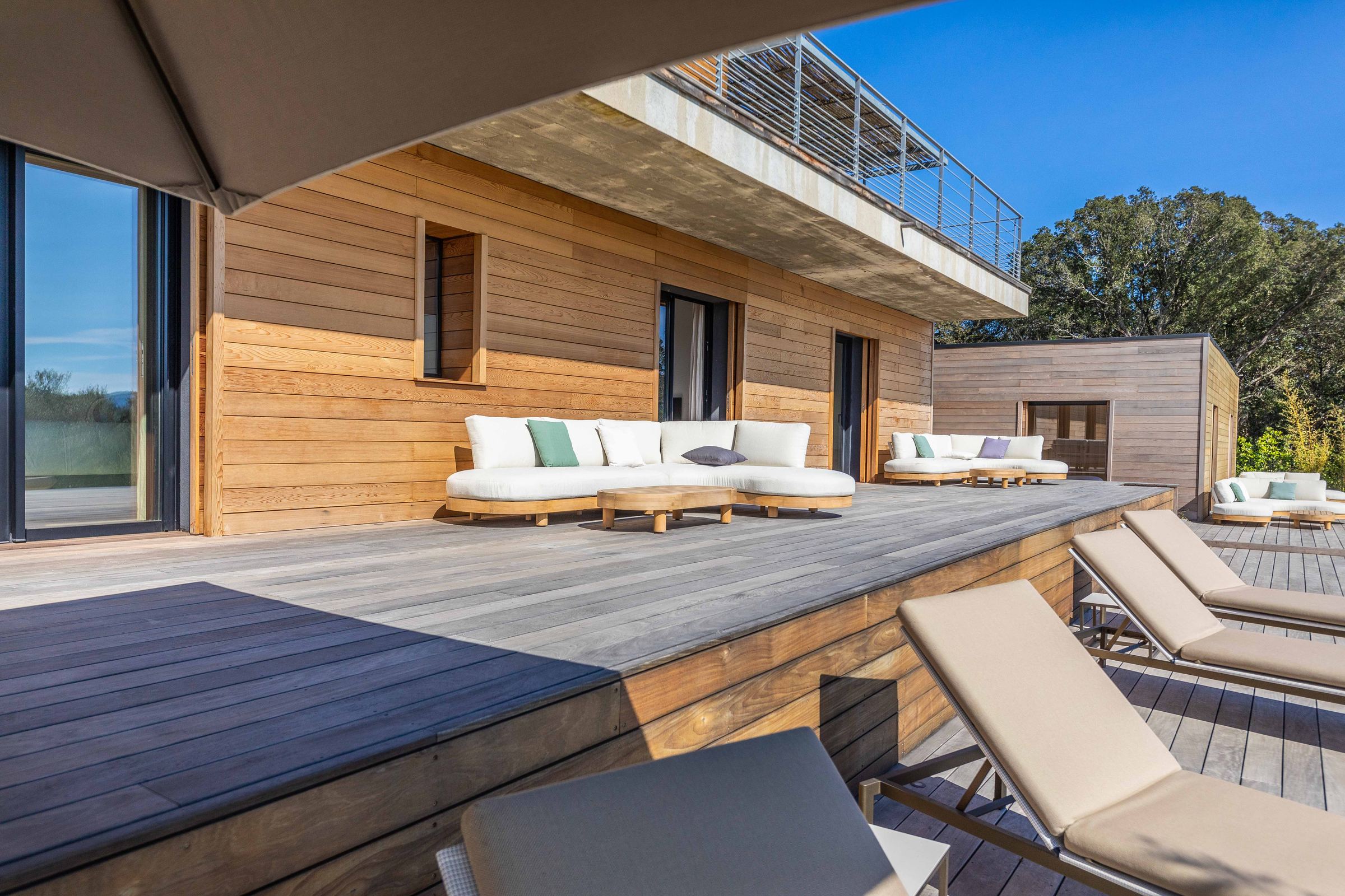 Timber terrace and loungers under an olive tree